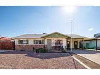 Charming single-story home with a covered porch and desert landscaping, perfect for enjoying the Arizona sunshine at 6815 W Reade Ave, Glendale, AZ 85303