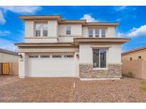 Stylish two-story home showcasing a brick driveway, a two-car garage, and stone veneer accents at 7694 W Crabapple Dr, Peoria, AZ 85383