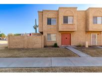 Tan two-story townhome with red door and small front yard at 948 S Alma School Rd # 29, Mesa, AZ 85210