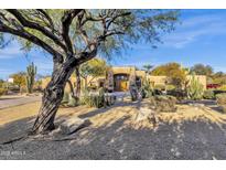 Stunning Southwestern-style home featuring mature trees and desert landscaping, creating an inviting outdoor space at 9980 E Charter Oak Rd, Scottsdale, AZ 85260