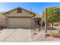 Tan house with stone accents, two-car garage, and desert landscaping at 11153 E New Frontier Ct, Gold Canyon, AZ 85118