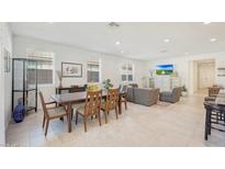 Open concept dining area with modern table and adjacent living room at 12530 W Levi Dr, Avondale, AZ 85323