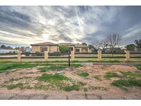 Single story home with beige stucco, tile roof, wood fence and manicured front yard at 1716 S 141St Pl, Gilbert, AZ 85295