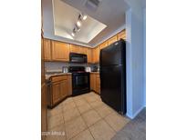 Well-lit kitchen with wood cabinets, black appliances, and tile flooring at 1825 W Ray Rd # 2031, Chandler, AZ 85224