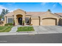 Tan two-story house with three-car garage and lush landscaping at 1890 W Wisteria Dr, Chandler, AZ 85248
