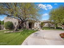 Stunning single-story home with circular drive, lush landscaping, and mature trees on a sunny day at 300 N Portland Ave, Gilbert, AZ 85234
