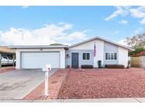 Ranch style home with attached garage and landscaped front yard at 3837 W Port Au Prince Ln, Phoenix, AZ 85053