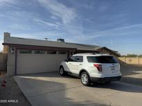 Tan house with a two-car garage and a driveway, set against a clear sky at 4830 S 22Nd Pl, Phoenix, AZ 85040