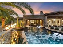 Luxury backyard oasis with a sparkling pool, fire feature, and ample seating at 8124 E Paraiso Dr, Scottsdale, AZ 85255