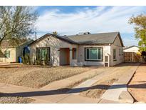 Charming single-story home with desert landscaping, and a long driveway under a blue sky at 1934 E Brill St, Phoenix, AZ 85006