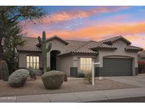 Charming single-story home featuring desert landscaping and a tile roof set against a vibrant sunset sky at 20490 N 78Th Way, Scottsdale, AZ 85255