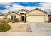 Tan house with a two-car garage and landscaped yard at 25740 W Watkins St, Buckeye, AZ 85326