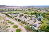 Panoramic aerial view of a golf course community featuring well-manicured lawns, mature trees, and a stunning mountain backdrop at 28247 N 128Th Dr, Peoria, AZ 85383