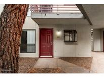 Red front door of condo with small window detail and a tree on the side at 3405 W Danbury Dr # D121, Phoenix, AZ 85053