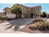 A beautiful exterior shot showing the home's driveway and desert landscaping at 42531 W Chisholm Dr, Maricopa, AZ 85138