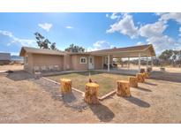 Charming backyard with grassy area and log seating at 6210 N Poplar St, Maricopa, AZ 85139