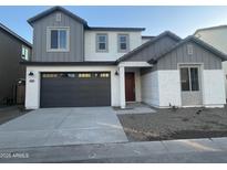 Two-story home with gray siding, dark gray garage door, and landscaping at 9227 E Sector Dr, Mesa, AZ 85212