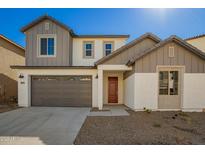 Charming two-story home featuring a gray garage door and a red front door, complemented by neutral-toned siding and gravel landscaping at 9227 E Sector Dr, Mesa, AZ 85212