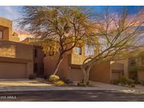 Tan stucco exterior, two-car garage, desert landscaping at 25555 N Windy Walk Dr # 58, Scottsdale, AZ 85255
