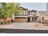 Inviting two-story home with a tan exterior, charming curb appeal and a two-car garage at 35598 N Murray Grey Dr, San Tan Valley, AZ 85143