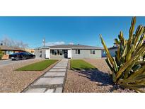 Cute bungalow with artificial turf, stone pathway, and mature cactus at 3714 E Amelia Ave, Phoenix, AZ 85018