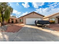 Tan house with white garage door and landscaping at 4510 N 84Th Ave, Phoenix, AZ 85037