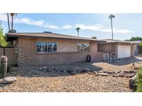 Brick ranch house with a two-car garage and landscaped yard at 4511 W Sandra Ter, Glendale, AZ 85306