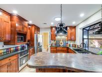 Stunning kitchen boasts custom cabinets, stainless steel appliances, granite counters, and unique backsplash at 6720 E Phelps Rd, Scottsdale, AZ 85254