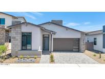 Stunning modern home with neutral stucco, stone accents, stylish garage door and desert landscaping at 6727 N 9Th Dr, Phoenix, AZ 85013