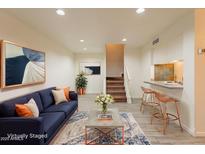 Inviting living room showcasing a blue sofa, stylish rug, and a bar counter with seating at 8446 N 34Th Dr, Phoenix, AZ 85051