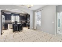 Eat-in kitchen features dark cabinetry, stainless steel appliances, and a functional center island at 17749 W Woodrow Ln, Surprise, AZ 85388