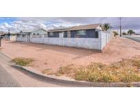 Ranch style home with blue exterior, solar panels, and a gated front yard at 203 E Beech Ave, Casa Grande, AZ 85122