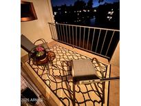 Cozy balcony features chairs, patterned rug, and a serene view of the lake at night at 2524 S El Paradiso -- # 121, Mesa, AZ 85202