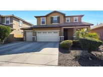 Two-story house with beige exterior, three-car garage, and landscaping at 3501 E Apricot Ln, Gilbert, AZ 85298