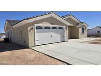 Single-story home features a concrete driveway and attached two-car garage at 5403 S 360 Th Ave, Tonopah, AZ 85354