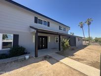 Charming two-story home with a covered entryway, freshly painted exterior, and desert landscaping at 925 W Fairway Dr, Mesa, AZ 85201