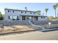 Two-story house with gray siding, stone wall, and a wood-framed entryway at 925 W Fairway Dr, Mesa, AZ 85201