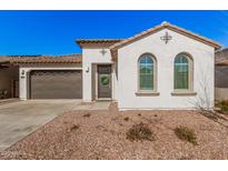 Single-story home with a two-car garage and desert landscaping at 17022 W Echo Ln, Waddell, AZ 85355