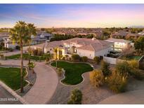 Expansive desert home boasts meticulous landscaping, palm trees, and a circular driveway at 2916 E Arrowhead Trl, Gilbert, AZ 85297