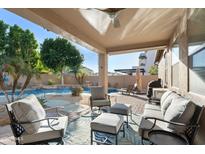 Relaxing covered patio seating area with an outdoor kitchen and backyard swimming pool at 3115 E Turnberry Dr, Gilbert, AZ 85298