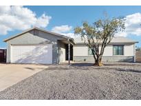 Single story home with a white exterior, two-car garage, and gravel driveway at 3410 E Everett Dr, Phoenix, AZ 85032