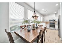 Bright dining area with wood table and chairs, adjacent to kitchen at 42424 N Gavilan Peak Pkwy # 47102, Anthem, AZ 85086