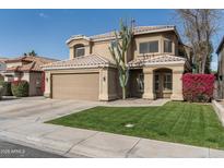 Charming home featuring a well-manicured front lawn, mature landscaping, and a two-car garage at 4760 W Tulsa St, Chandler, AZ 85226