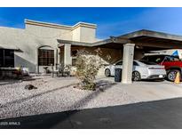 Front view of a stucco home with carport, small patio, and landscaped yard at 7708 E Park View Dr Dr, Mesa, AZ 85208