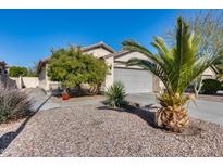 Single-story house with two-car garage, desert landscaping, and walkway at 13814 W Elm St, Surprise, AZ 85374