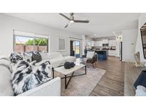Bright living room with white sofa, ceiling fan, marble coffee table, and access to the kitchen at 2776 E Mews Rd, Gilbert, AZ 85298