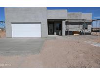 Contemporary home exterior with a two-car garage and modern design elements under construction at 28551 N 257Th Ave, Wittmann, AZ 85361