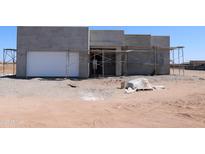 Contemporary home under construction with a white garage door and scaffolding in place at 28551 N 257Th Ave, Wittmann, AZ 85361