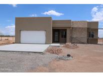 Contemporary home featuring a stucco exterior, attached garage, and desert landscaping at 28615 N 257Th Dr, Wittmann, AZ 85361