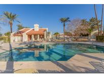Community pool with surrounding patio furniture and palm trees at 3535 W Monte Cristo Ave # 101, Phoenix, AZ 85053